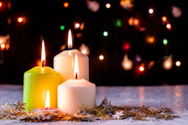 Siyah Noel arkaplanı renkli ışıklar yanan mumlar ve ön planda dekoratif kar taneleri. Yüksek kalite fotoğraf