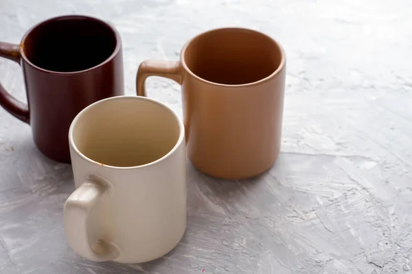 3つの空のコーヒーマグカップコピースペースと灰色の漆喰の表面 — ストック写真