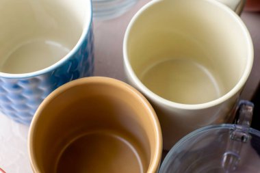 Masanın üzerinde farklı şekil ve boyutlarda boş kupalar