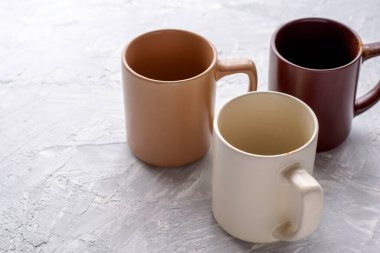 Gri alçılı yüzeyde üç boş kahve fincanı var. Yüksek kalite fotoğraf