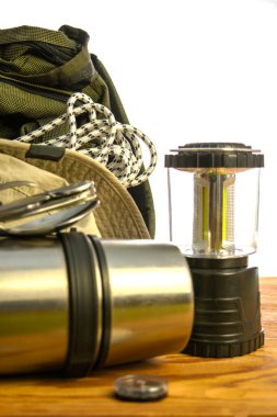 Turist sırt çantası termos tırmanma halatı pusula katlama fener ve beyaz arka planda ahşap zemin üzerinde şapka. Yüksek kalite fotoğraf