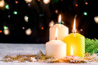 Siyah Noel arkaplanı renkli ışıklar yanan mumlar ve ön planda dekoratif kar taneleri. Yüksek kalite fotoğraf