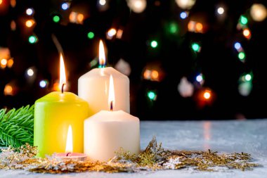 Siyah Noel arkaplanı renkli ışıklar yanan mumlar ve ön planda dekoratif kar taneleri. Yüksek kalite fotoğraf