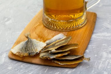 Kesme tahtasında bir bardak bira ve kurutulmuş balık. Yüksek kalite fotoğraf
