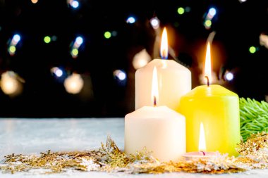 Siyah Noel arkaplanı renkli ışıklar yanan mumlar ve ön planda dekoratif kar taneleri. Yüksek kalite fotoğraf