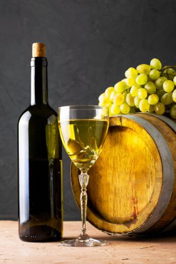 Bir şişe şarap bir bardak meşe fıçısı ve arka planda bir sürü beyaz üzüm. Yüksek kalite fotoğraf