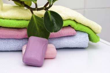 Bir yığın havlu, sabun ve tuvalet masasının üzerinde bir saksı. Yüksek kalite fotoğraf