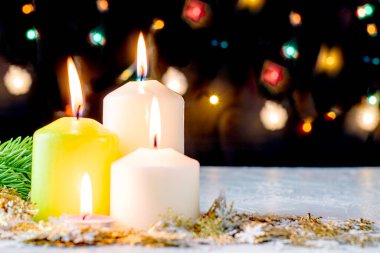 Siyah Noel arkaplanı renkli ışıklar yanan mumlar ve ön planda dekoratif kar taneleri. Yüksek kalite fotoğraf