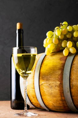 Bir şişe şarap bir bardak meşe fıçısı ve arka planda bir sürü beyaz üzüm. Yüksek kalite fotoğraf