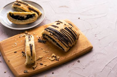 Dilimlenmiş puf böreği, haşhaş tohumu ve çikolata, kesme tahtası ve tabakta. Yüksek kalite fotoğraf