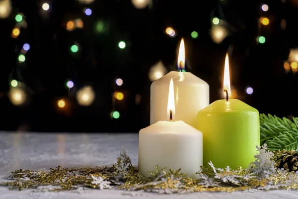 Siyah Noel arkaplanı renkli ışıklar yanan mumlar ve ön planda dekoratif kar taneleri. Yüksek kalite fotoğraf