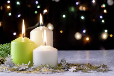 Siyah Noel arkaplanı renkli ışıklar yanan mumlar ve ön planda dekoratif kar taneleri. Yüksek kalite fotoğraf