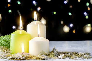 Siyah Noel arkaplanı renkli ışıklar yanan mumlar ve ön planda dekoratif kar taneleri. Yüksek kalite fotoğraf