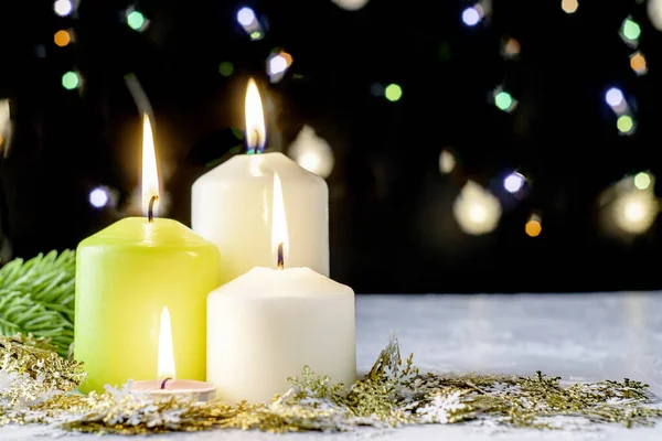Siyah Noel arkaplanı renkli ışıklar yanan mumlar ve ön planda dekoratif kar taneleri. Yüksek kalite fotoğraf