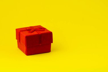 Kırmızı hediye kutusu, sarı arka planda, kopyalanmış. Yüksek kalite fotoğraf