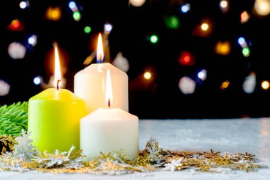 Siyah Noel arkaplanı renkli ışıklar yanan mumlar ve ön planda dekoratif kar taneleri. Yüksek kalite fotoğraf