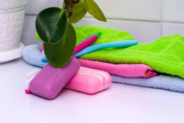 Bir yığın havlu diş fırçası ve tuvalet masasının üzerinde bir saksı. Yüksek kalite fotoğraf