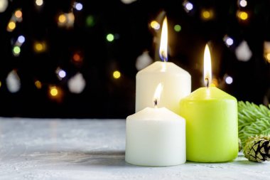 Siyah Noel arka planında renkli ışıklar ve ön planda yanan mumlar var. Yüksek kalite fotoğraf