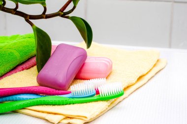 Bir yığın havlu diş fırçası ve tuvalet masasının üzerinde bir saksı. Yüksek kalite fotoğraf