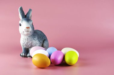 Tavşan ve pembe arka planda çok renkli paskalya yumurtaları. Yüksek kalite fotoğraf