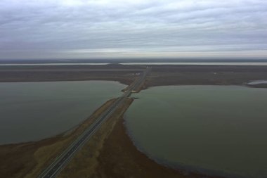 Asfalt yol ve bir göl üzerinde köprü bozkır fotoğrafında dörtgen bir manzaradan. Yüksek kalite fotoğraf