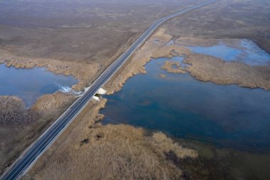Asfalt yol ve bir göl üzerinde köprü bozkır fotoğrafında dörtgen bir manzaradan. Yüksek kalite fotoğraf
