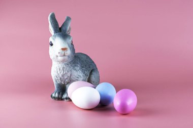 Tavşan ve pembe arka planda çok renkli paskalya yumurtaları. Yüksek kalite fotoğraf