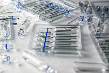 Beyaz zemin üzerinde cam ampulleri ve ayrı ampulleri olan şeffaf plastik kaplar. Yüksek kalite fotoğraf