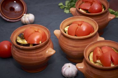 Kişniş 'in yanındaki fırında pişirmek için tencerede Chanakhi pişiyor. Yüksek kalite fotoğraf