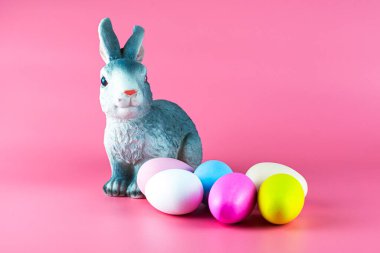 Tavşan ve pembe arka planda çok renkli paskalya yumurtaları. Yüksek kalite fotoğraf