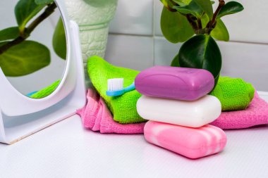 Havlular, sabun, diş fırçası aynası ve tuvalet masasının üzerindeki saksı. Yüksek kalite fotoğraf