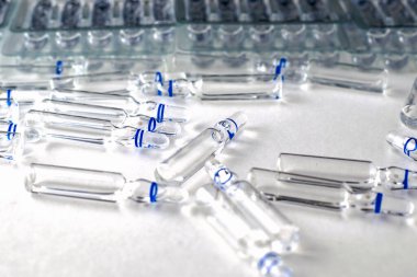 Beyaz zemin üzerinde cam ampulleri ve ayrı ampulleri olan şeffaf plastik kaplar. Yüksek kalite fotoğraf