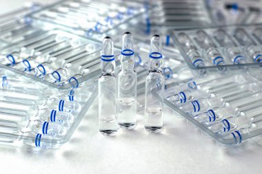 Beyaz zemin üzerinde cam ampulleri ve ayrı ampulleri olan şeffaf plastik kaplar. Yüksek kalite fotoğraf