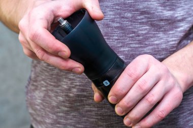 Kahve öğütücüsünde kahve öğüten bir adam kahve öğütücüsünden öğütülmüş kahve için vidaları söker. Yüksek kalite fotoğraf