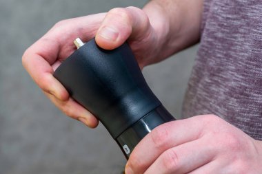 Kahve öğütücüsünde kahve öğüten bir adam kahve öğütücüsünden öğütülmüş kahve için vidaları söker. Yüksek kalite fotoğraf