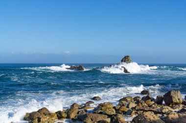İspanya, Tenerife yakınlarındaki dalgalı Atlantik Okyanusu, sudaki kayalıklarda güçlü dalgalar kopuyor.