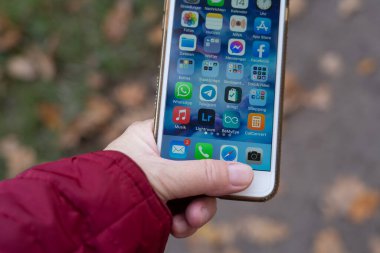 Elinde bir sürü aplikasyon olan bir cep telefonu tutan beyaz bir kadın.