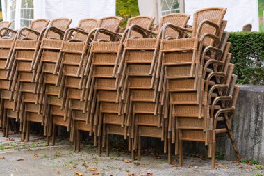 Restoranın önüne yığılmış bir sürü hasır sandalye.