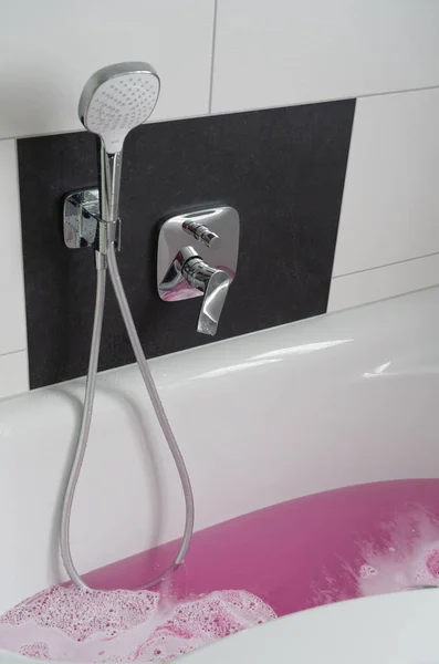 浴槽はピンク色のお湯と白い泡 — ストック写真