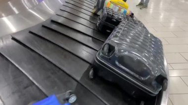 Larnaca Uluslararası Havaalanı yolcu terminalindeki varış noktasında valiz taşıma bandında çeşitli bavullar var.