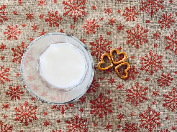 牛奶在杯子里 饼干在上方 圣诞饮品有雪花的圣诞背景 — 图库照片