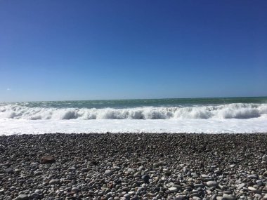 Dalgalar Breaking ve Püskürtme High Seas ve Güçlü Rüzgarlar wth güneş.