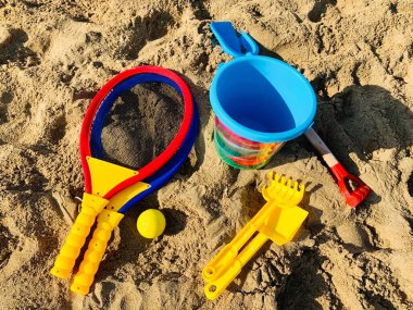 Çocukların kumsaldaki plastik oyuncaklarının tatil görüntüsü.