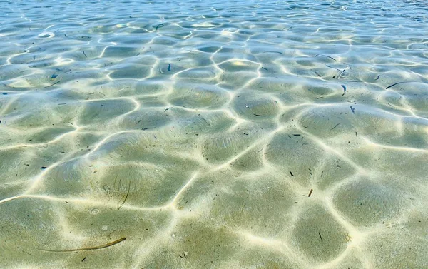 Bella acqua blu chiaro con onde e raggi nel mare. Vacanze estive e piscina. — Foto Stock