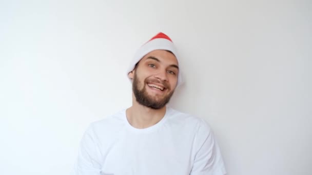 Homem Bonito Caucasiano Chapéu Vermelho Papai Noel Fundo Branco Sorri — Vídeo de Stock