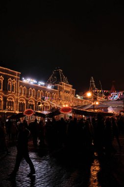 18.12.2021 Rusya Moskova. Şehrin sokaklarında parlak çelenkler ve renkli bayraklar süslenmiştir. Kızıl Meydan 'daki Noel pazarında bir sürü insan var..