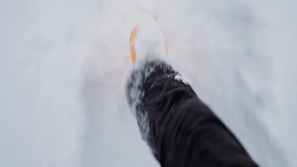 足の上からの眺めで雪を蹴る 4K映像のスローモーション 雪の冬の天気 新鮮な空気中を歩く 霜の日にふわふわの雪 黄色のゴム製のブーツを歩く — ストック動画