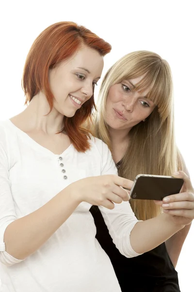 Hermosas chicas de pelo rubio y rojo muestran algo en su teléfono —  Fotos de Stock