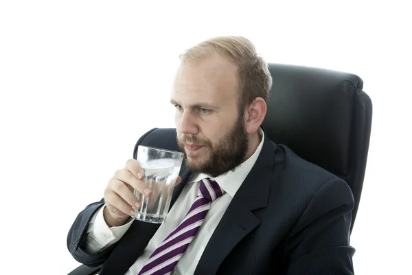 ひげビジネス男ガラス水を飲む作業中 — ストック写真