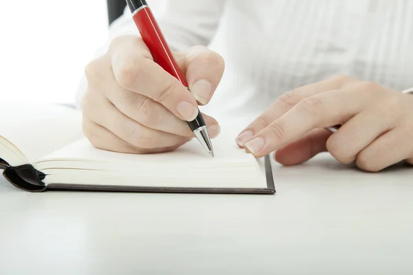 Νεαρή μελαχρινή επιχειρηματίας με γυαλιά που γράφει το κείμενο βιβλίο με στυλό — Φωτογραφία Αρχείου